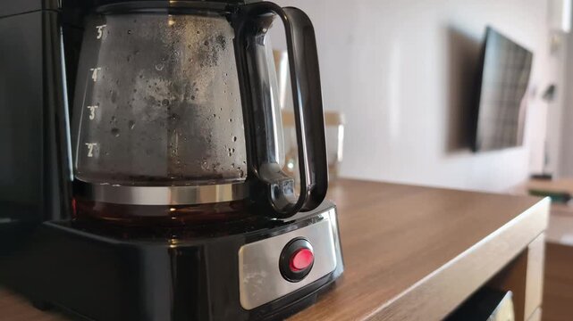 Drip coffee machine making coffee in hotel room