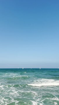 POV from phone sail boats at sea or ocean during summer sunny day outdoors. Vertical social media reel UGC content style of perfect day for sailing. Point of view from shore to Mediterranean Sea