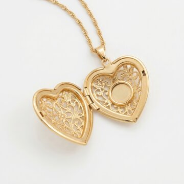 An elegant open golden filigree heart-shaped locket with copy space isolated on a white background