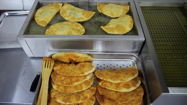 Lots of fried chebureks are on the counter in the dining room or at the buffet. The idea of catering and takeaway food.