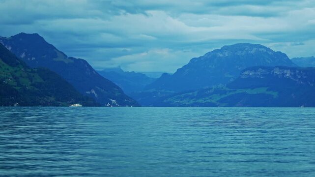 Lake Lucerne with Swiss Alps and Sailboats near Weggis, Switzerland. Vierwaldstaettersee waterfront panorama. Buergenstock and Weggis scenery. Peaceful alpine nature. Central Switzerland lake view.