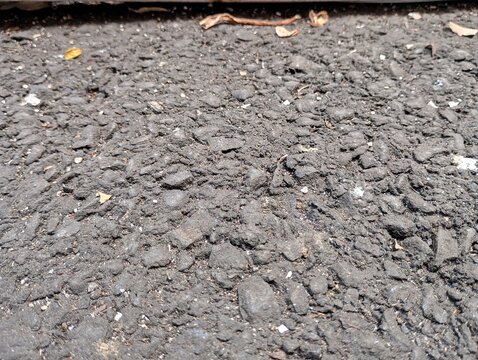 Close up view of rough grey asphalt road surface texture.