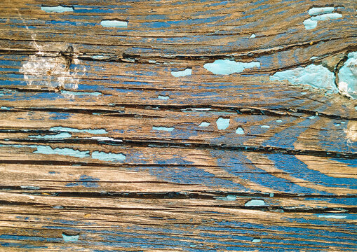 Old blue cracked paint on top of a wooden table. Texture and grunge background.