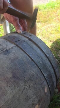 craftsman carpenter repairing wooden barrel