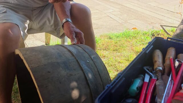 craftsman carpenter repairing wooden barrel