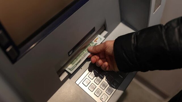 Close up of man hands receiving american dollar money banknotes from automated teller machine slot for cash withdrawal in 4K Ultra HD footage
