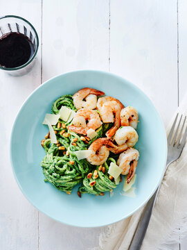 Pesto shrimp pasta with pine nuts and parmesan, gourmet dining experience, elegant restaurant menu