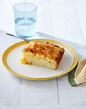 Pineapple upside-down cake slice on plate, paired with refreshing water, dessert menu concept