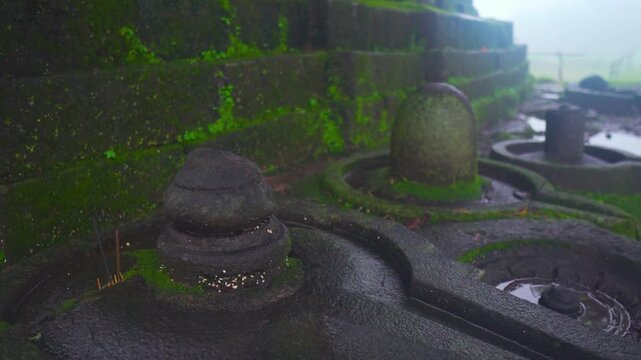 Closeup shot of Shiva Linga besides an old temple at Nageshwar temple at Khireshwar near Malshej Ghat in Maharashtra, India during the monsoon season. A sacred symbol of Lord Shiva in Hinduism.
