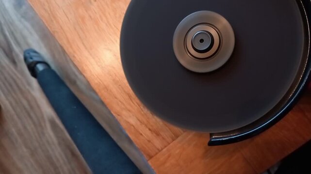 High-pitched sound of angle grinder resting on wood surface with metal shutdown ring in focus