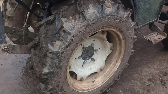Tractor reversing with low idle and background sounds of power steering and rumbling in a muddy field setting