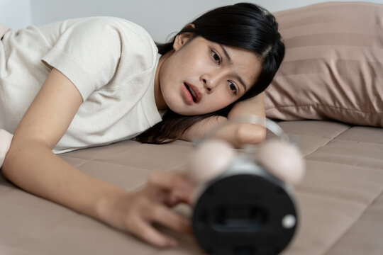 Shocked Asia young woman looking at clock alarm, lady is late appointment or work or class study, overslept, difficulty get up in mornings, time worried, not on time, sleepy, over due, Hurry up time