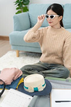 Traveler. female is preparing and test sunglasses for travel. women are prepare clothes and personal belongings. Pack your luggage before travel. holiday, vacation time, long weekend, summer