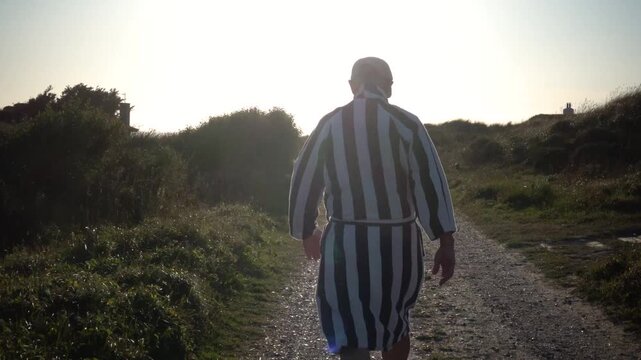 Hirtshals, Denmark A man walks in the sandy and grassy North Sea dunes at sunset. 