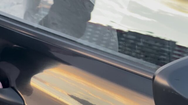 Male hand opening a black car door handle outdoors, car access, vehicle detail, auto care, road transport.