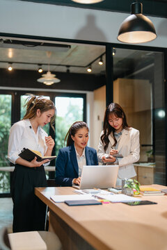 Asian mentor and supervisor working together to support training of office trainee in business strategy
