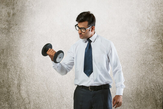 Young businessman lifting weights