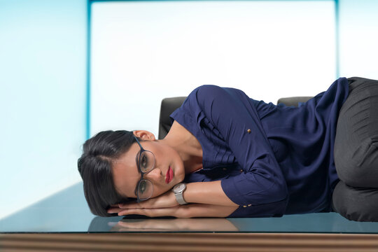 Businesswoman lying on desk in office