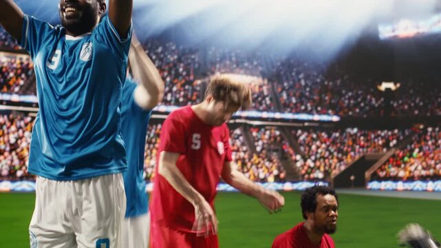 Football celebration after match winning goal as goal scorer raises arms, smiling and celebrating with clenched fists, excitement on pitch after final whistle.
