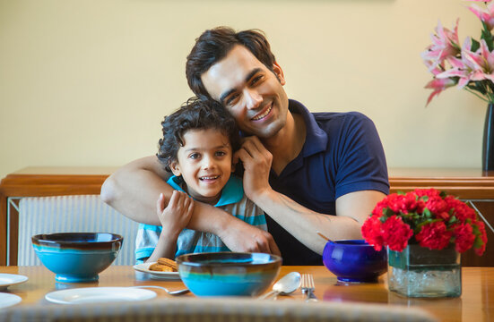 Portrait of father and son at dinning table
