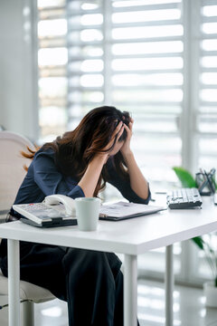 Tired and exhausted, Frustrated business woman sitting in an office desk