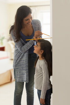 Mother measuring daughter height