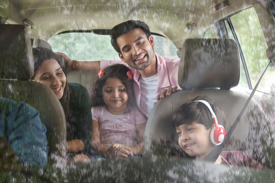 Smiling family in car for road trip
