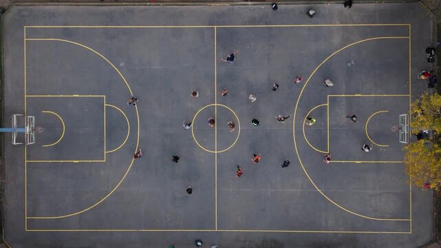 A lot of people taking a Zumba class on a basketball court. Aerial