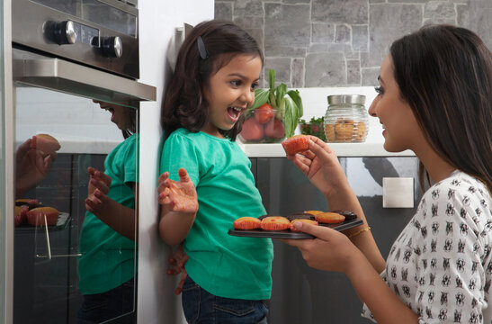 Mother giving daughter cupcakes