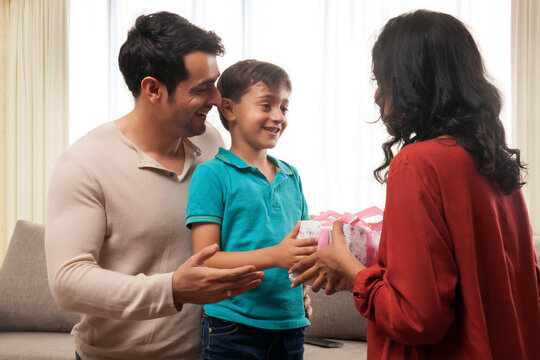 Parents presenting gift to son