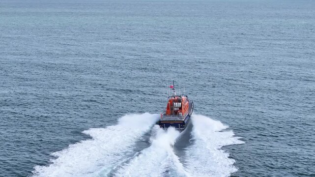 Bembridge UK RNLI lifeboat speeding out to sea drone tracking shot