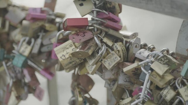 Hundreds of padlocks known as love locks are attached to a bridge railing in Paris, a popular romantic tradition.