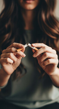 Person breaking cigarette in half, symbolizing quitting smoking and healthy choice. Concept for health and wellness.