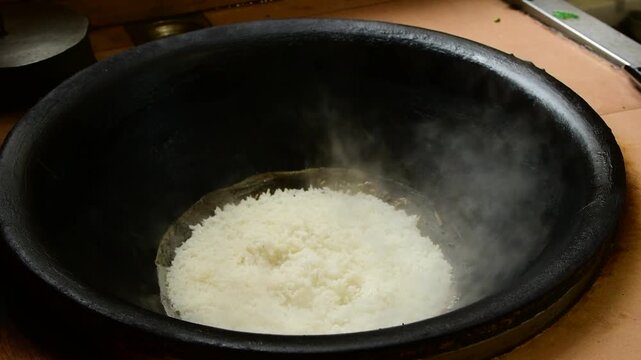 Fresh Cooked White Rice Steaming in Traditional Dark Iron Pot