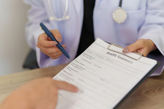 Doctor handing health summary report to patient during medical consultation in clinic