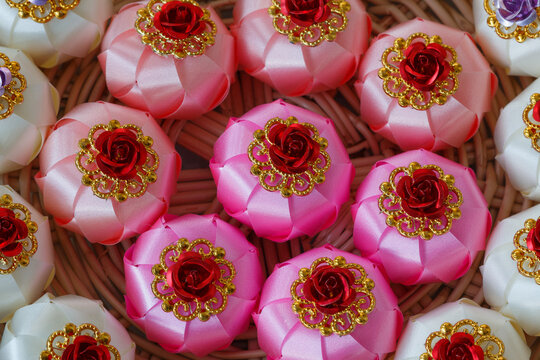 Handmade craft Thai festival decoration,Coins wrapped in floral ribbons on a basket against   background.
