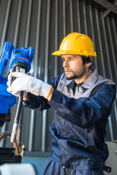 Industrial engineers inspecting and calibrating robotic arm systems in smart factory. automation technology, preventive maintenance, quality control, manufacturing solutions.