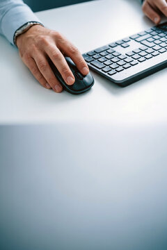 Close-up of a person using a computer mouse and keyboard