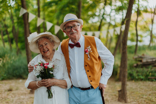 Senior couple having marriage in nature during autumn day.