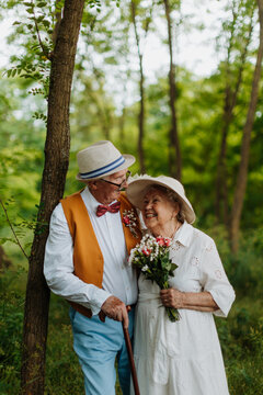Senior couple having marriage in nature during autumn day.