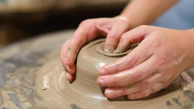Artisan Hands Shaping Wet Clay on a Rotating Pottery Wheel