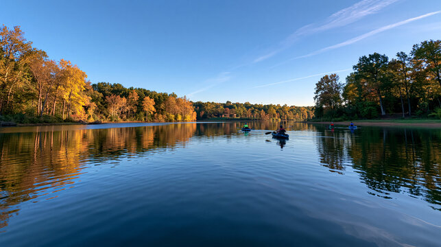 People Kayaking on Scenic Lake Surrounded by Autumn Foliage