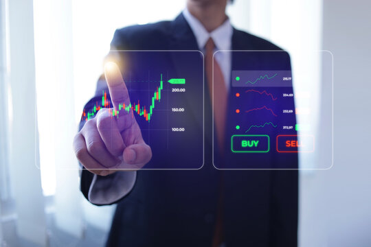 Investor Interacting With Stock Candlestick Hologram And Buy Sell Buttons In Office Room