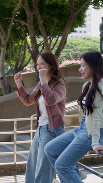 Two Happy Asian Students Talking and Cheering on University Campus