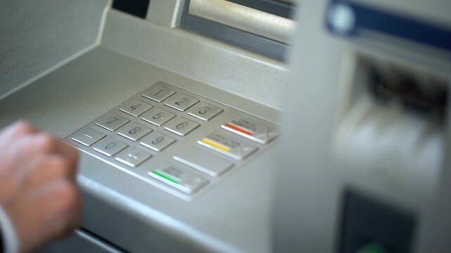 Businessman entering his pin code on keyboard of ATM machine for secure banking services and finance in 4K Ultra HD footage
