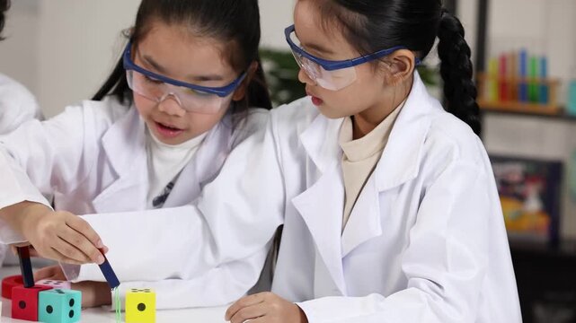 Asian Elementary Students Conducting Magnetism Experiment in Science Lab