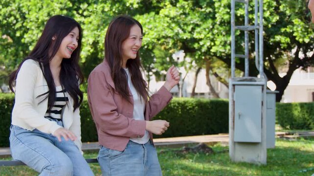 Two Asian Female Students Talking and Laughing on University Campus