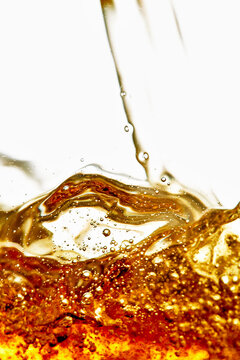 Golden Amber Liquid Pouring with Bubbles and Splash Motion