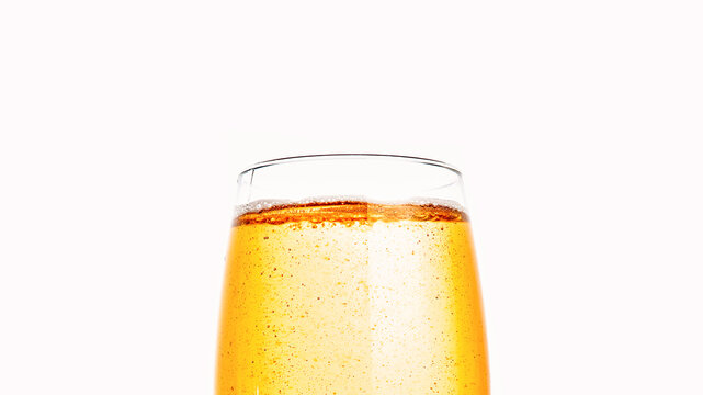 Close up of a glass of sparkling golden beer isolated on white background