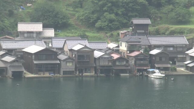 A panning shot&mdash;moving from left to right&mdash;of an overhead view of the *funaya* (boathouses) in Ine Town, Kyoto Prefecture.